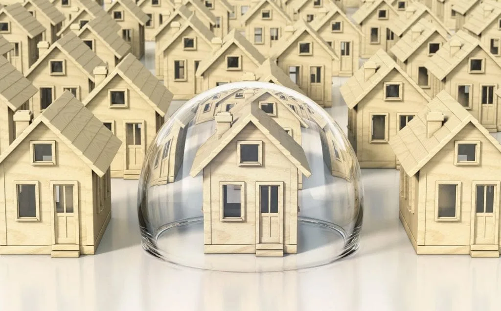 Model house protected under a glass dome among rows of houses