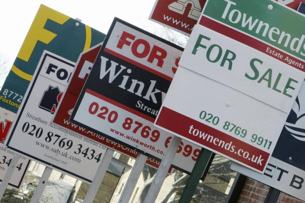 Row of estate agent For Sale signs