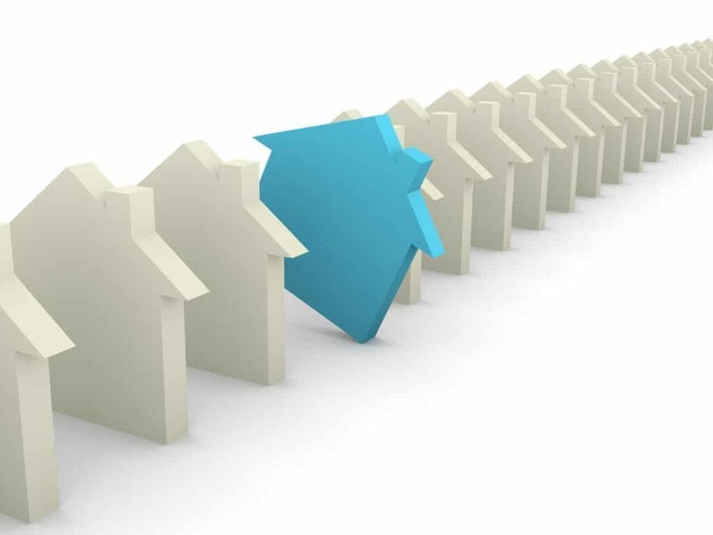 Line of model houses with one blue house standing out