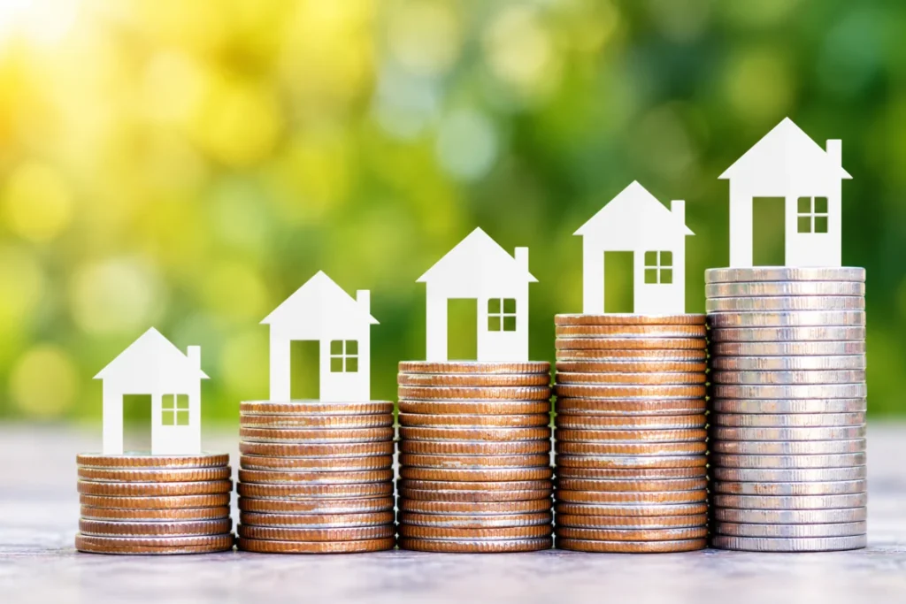 Model houses on rising stacks of coins